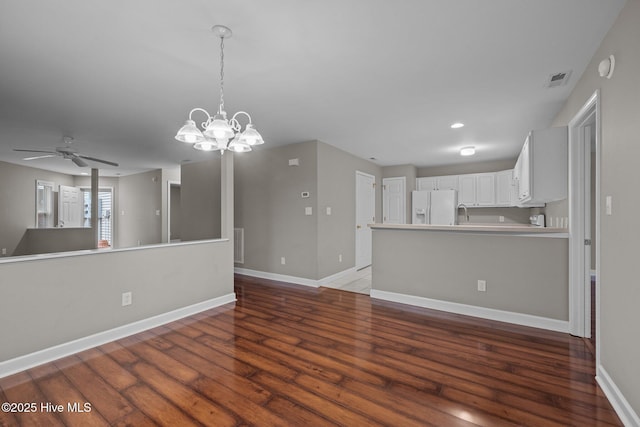 424 Commerce Ave Unit B, Morehead City, NC 28557 - unfurnished living room with wood finished floors, baseboards, visible vents, and ceiling fan with notable chandelier