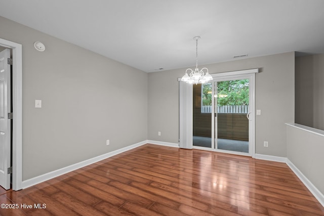 424 Commerce Ave Unit B, Morehead City, NC 28557 - empty room featuring an inviting chandelier, visible vents, wood finished floors, and baseboards