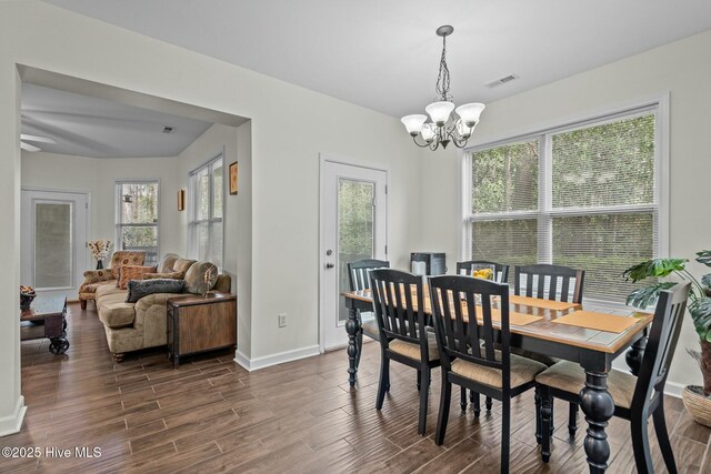 dining area featuring dark wood-style floors, baseboards, a chandelier, and visible vents