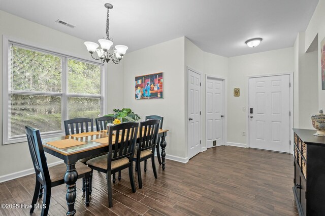 dining room featuring baseboards, visible vents, dark wood-type flooring, and a chandelier