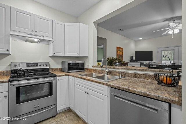 kitchen with white cabinetry, under cabinet range hood, a sink, ceiling fan, and appliances with stainless steel finishes