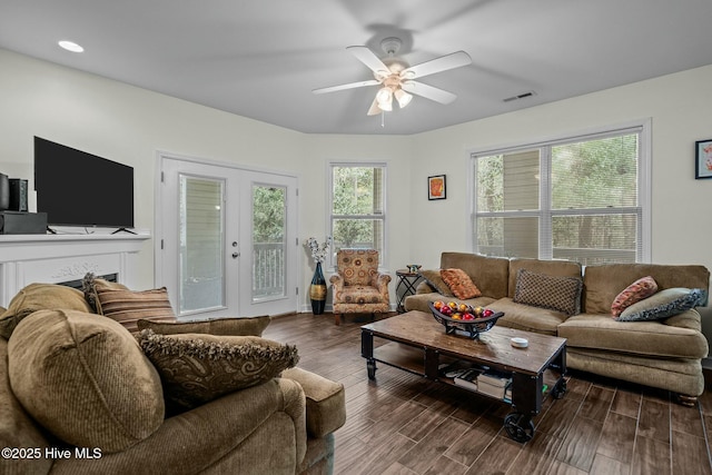 living area featuring visible vents, wood finished floors, and ceiling fan