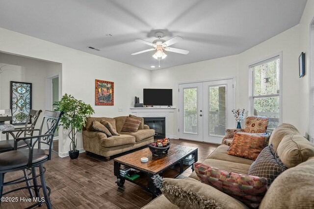 living area with dark wood finished floors, visible vents, french doors, and a ceiling fan