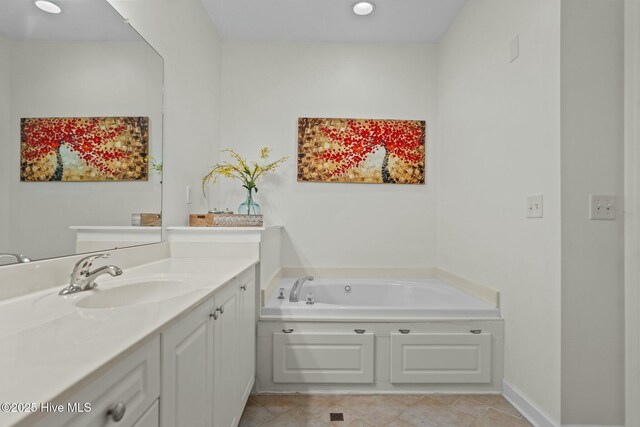full bathroom with tile patterned flooring, vanity, baseboards, and a bath