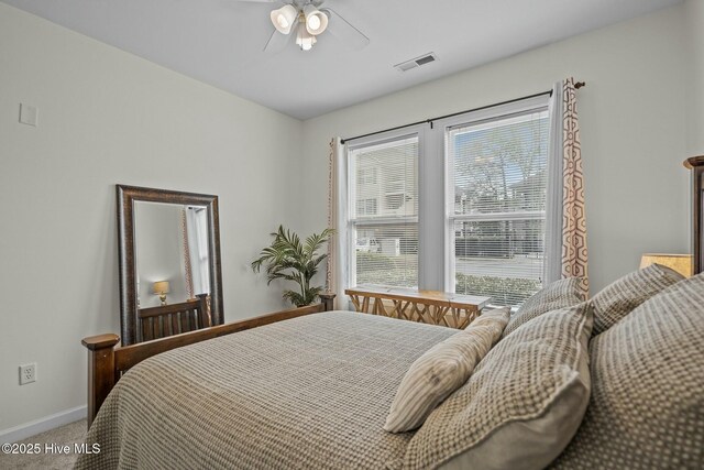 bedroom with baseboards, visible vents, ceiling fan, and carpet flooring
