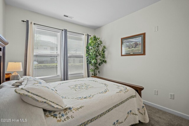 bedroom featuring baseboards, visible vents, and carpet
