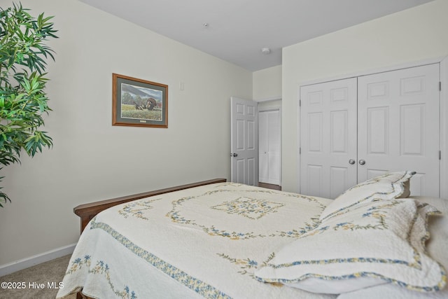 carpeted bedroom featuring baseboards and a closet
