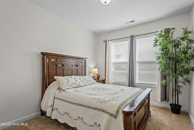 bedroom with baseboards, visible vents, and light colored carpet