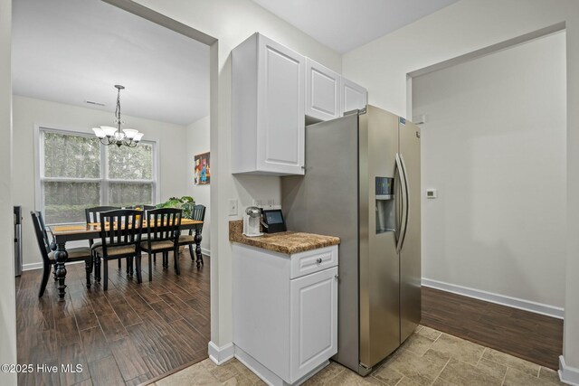 kitchen with a notable chandelier, wood finished floors, white cabinetry, and stainless steel refrigerator with ice dispenser