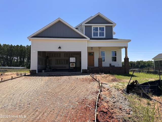 163 Noramac Ct, Selma, NC 27576 - view of front of home featuring dirt driveway, an attached garage, covered porch, and board and batten siding