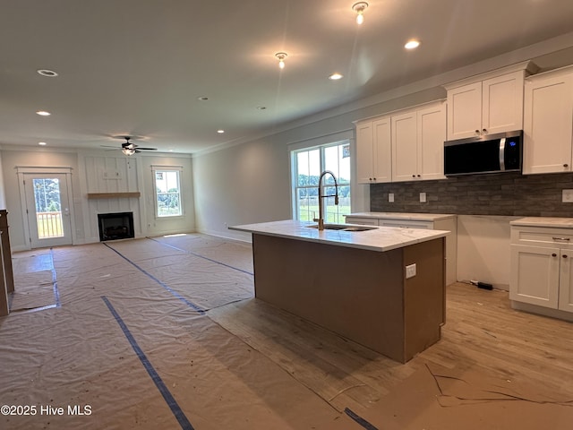 163 Noramac Ct, Selma, NC 27576 - kitchen with stainless steel microwave, crown molding, ceiling fan, healthy amount of natural light, and white cabinetry