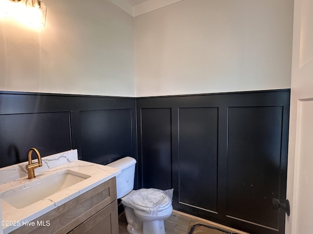 163 Noramac Ct, Selma, NC 27576 - half bathroom featuring a decorative wall, vanity, a wainscoted wall, and wood finished floors