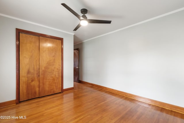 unfurnished bedroom featuring crown molding, light wood-style flooring, and baseboards