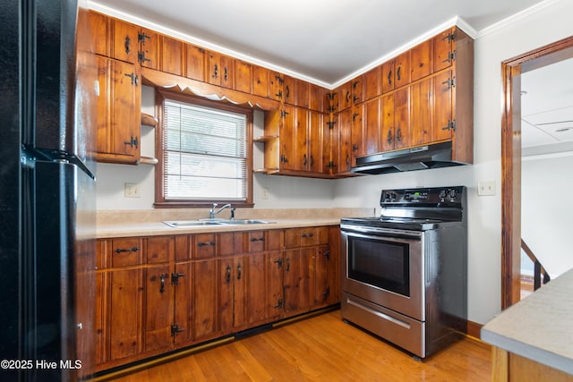 kitchen with stainless steel electric range oven, under cabinet range hood, light countertops, and a sink