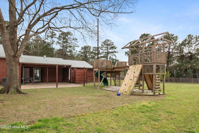 view of playground with a lawn, fence, central AC, and a patio area