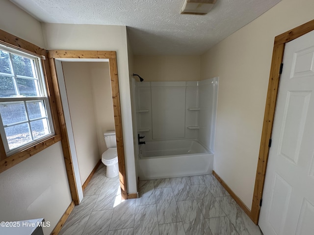 full bathroom featuring toilet, baseboards, shower / washtub combination, a textured ceiling, and marble finish floor
