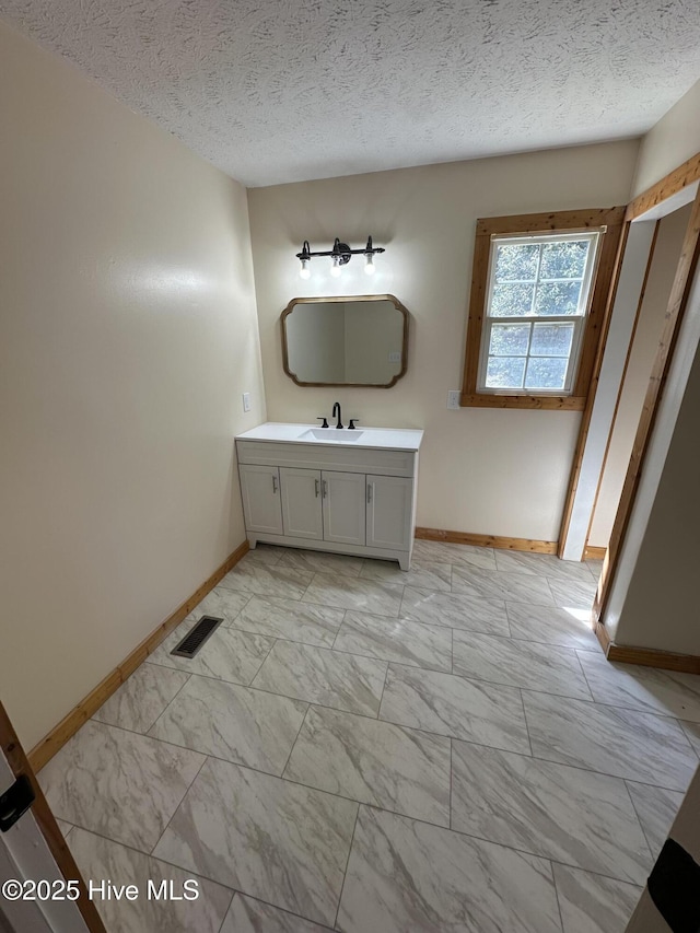 bathroom featuring marble finish floor, visible vents, vanity, and a textured ceiling