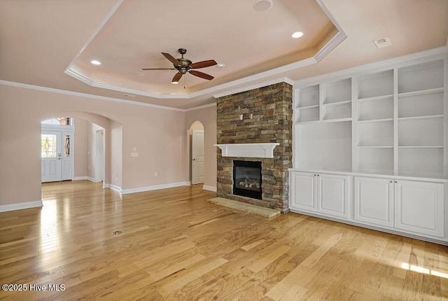 4021 Alastaire Cv, Leland, NC 28451 - unfurnished living room with arched walkways, a raised ceiling, baseboards, ceiling fan, and ornamental molding