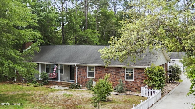 211 E 11th St, Southport, NC 28461 - view of front of home featuring a porch, brick siding, roof with shingles, and a chimney