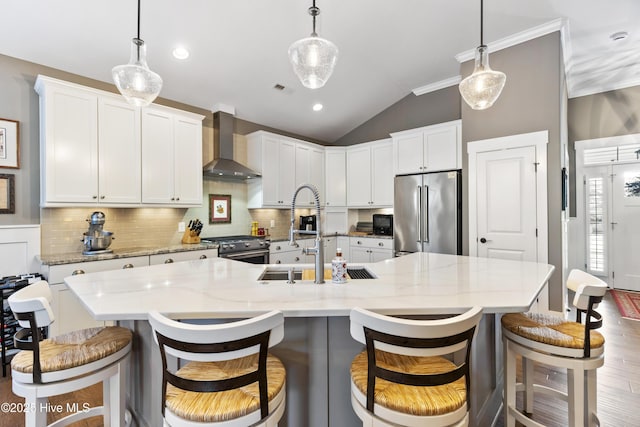 1443 Ellsworth Dr SW, Ocean Isle Beach, NC 28469 - kitchen with high quality appliances, wall chimney range hood, a sink, vaulted ceiling, and backsplash