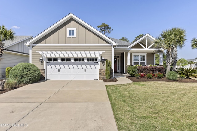 1443 Ellsworth Dr SW, Ocean Isle Beach, NC 28469 - craftsman-style home featuring board and batten siding, an attached garage, a front yard, concrete driveway, and stone siding