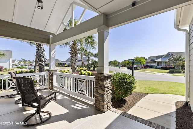 1443 Ellsworth Dr SW, Ocean Isle Beach, NC 28469 - covered porch with a residential view and a yard