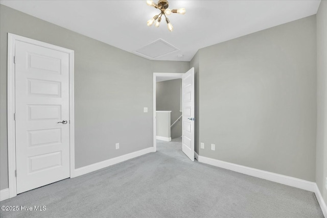 unfurnished bedroom with baseboards, carpet flooring, and attic access