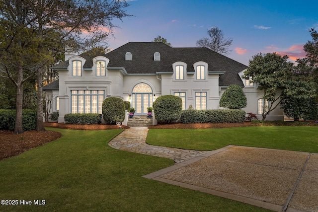 605 Dundee Dr, Wilmington, NC 28405 - french country home with a shingled roof, stucco siding, and a yard