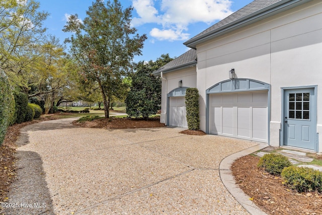 605 Dundee Dr, Wilmington, NC 28405 - view of home's exterior featuring driveway, a shingled roof, stucco siding, and a garage