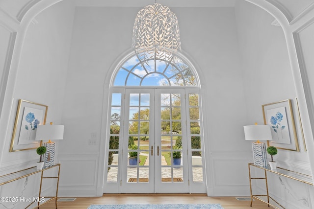 605 Dundee Dr, Wilmington, NC 28405 - doorway to outside with a decorative wall, a high ceiling, wainscoting, french doors, and wood finished floors