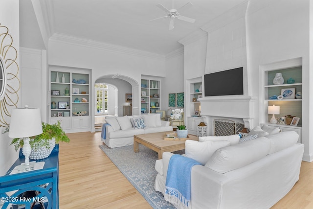 605 Dundee Dr, Wilmington, NC 28405 - living area with arched walkways, ceiling fan, built in features, crown molding, and light wood-style flooring