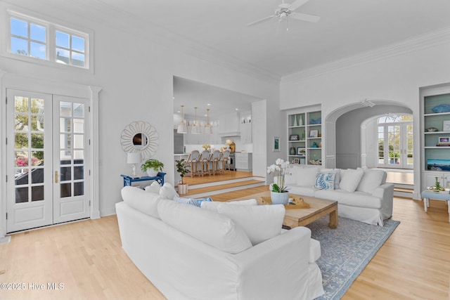 605 Dundee Dr, Wilmington, NC 28405 - living room with crown molding, ceiling fan, light wood-type flooring, arched walkways, and built in shelves