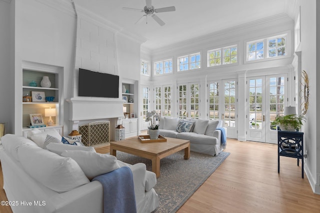 605 Dundee Dr, Wilmington, NC 28405 - living room with a towering ceiling, ornamental molding, a ceiling fan, light wood-style flooring, and built in shelves