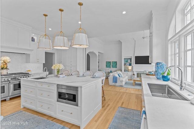 605 Dundee Dr, Wilmington, NC 28405 - kitchen featuring double oven range, a sink, white cabinets, open floor plan, and recessed lighting
