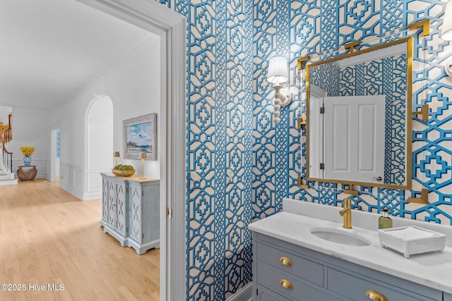 605 Dundee Dr, Wilmington, NC 28405 - bathroom with wallpapered walls, ornamental molding, vanity, and wood finished floors