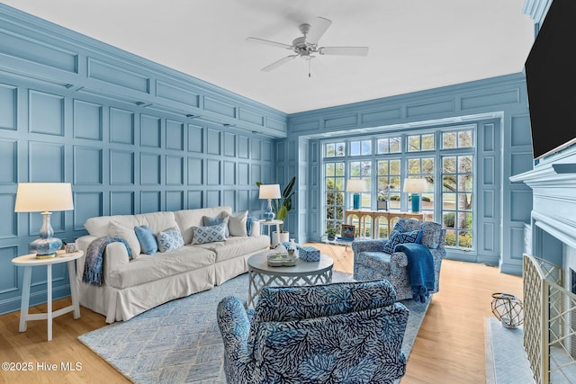 605 Dundee Dr, Wilmington, NC 28405 - living room with a decorative wall, light wood-style floors, a ceiling fan, and a fireplace with flush hearth
