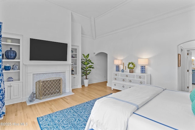 605 Dundee Dr, Wilmington, NC 28405 - bedroom with arched walkways, wood finished floors, crown molding, a towering ceiling, and a fireplace