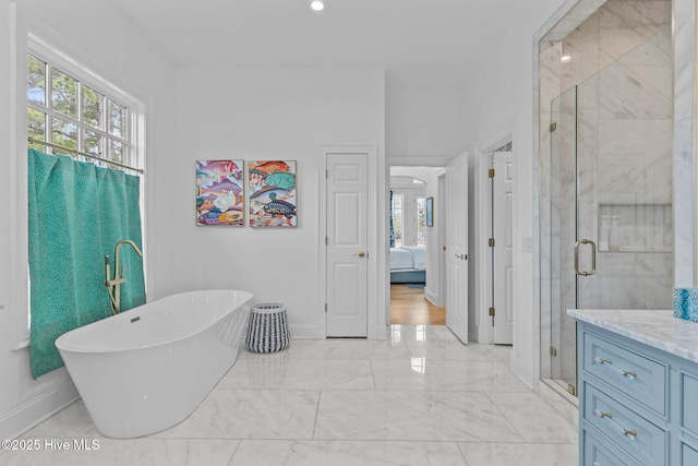 605 Dundee Dr, Wilmington, NC 28405 - ensuite bathroom with marble finish floors, a stall shower, a freestanding bath, baseboards, and vanity