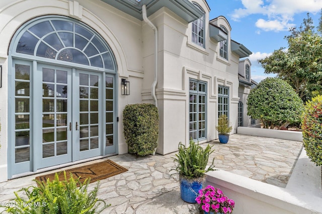 605 Dundee Dr, Wilmington, NC 28405 - view of exterior entry featuring french doors, stucco siding, and a patio area