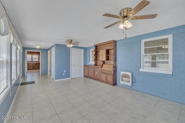 1317 Old Grantham Rd, Goldsboro, NC 27530 - unfurnished living room with ceiling fan, heating unit, light tile patterned floors, and brick wall