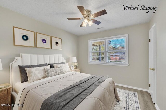 1317 Old Grantham Rd, Goldsboro, NC 27530 - bedroom featuring light wood-type flooring, a textured ceiling, and ceiling fan