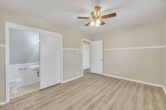 1317 Old Grantham Rd, Goldsboro, NC 27530 - unfurnished bedroom with wood finished floors, ceiling fan, and ensuite bathroom