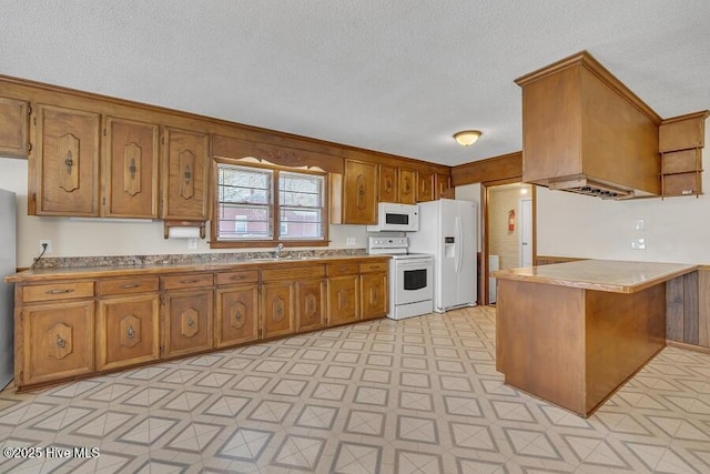 1317 Old Grantham Rd, Goldsboro, NC 27530 - kitchen with white appliances, brown cabinetry, light flooring, a textured ceiling, and a peninsula