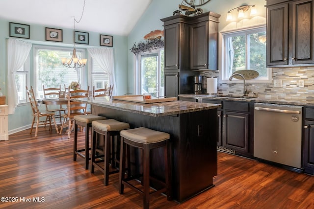 8713 Emerald Plantation Rd, Emerald Isle, NC 28594 - kitchen with dishwasher, a sink, lofted ceiling, a kitchen breakfast bar, and backsplash