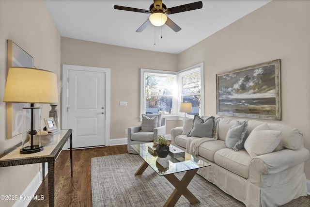 living room with baseboards, ceiling fan, and dark wood finished floors