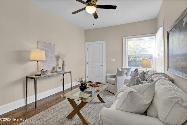 living area with baseboards, wood finished floors, and a ceiling fan