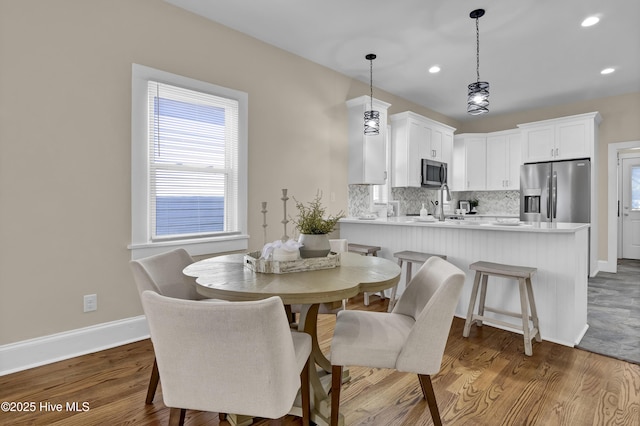 dining area featuring dark wood-style floors, baseboards, and recessed lighting