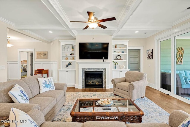 living room with crown molding, a ceiling fan, wood finished floors, and coffered ceiling