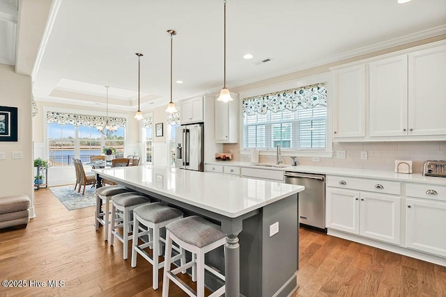 kitchen featuring crown molding, recessed lighting, a center island, a sink, and appliances with stainless steel finishes