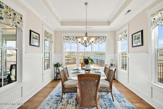 dining space featuring visible vents, wainscoting, plenty of natural light, and a decorative wall